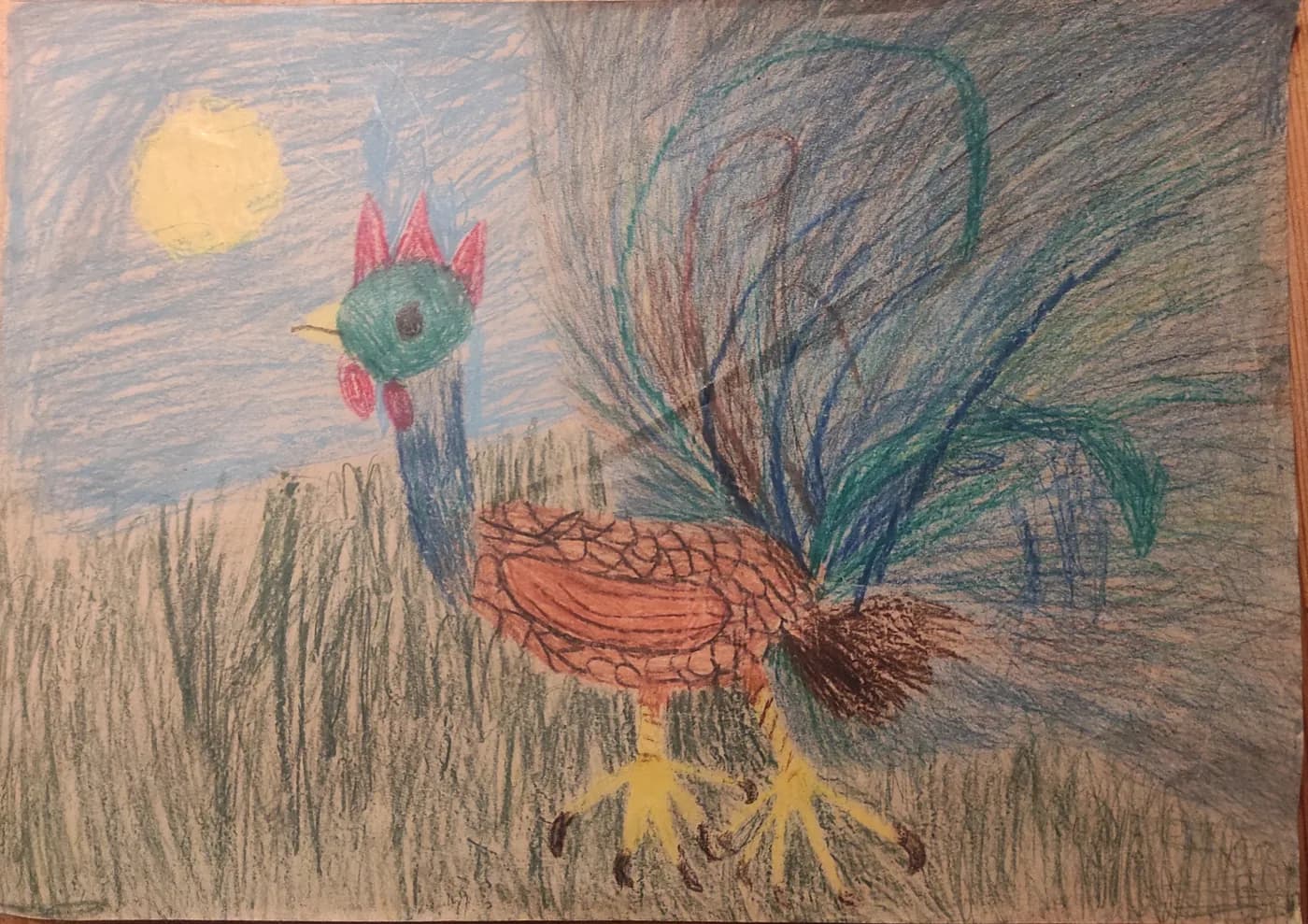 A child's crayon drawing of a rooster in tall grass under a yellow sun